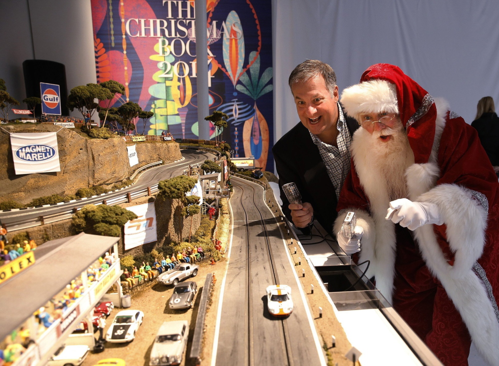 Slot Mods founder David Beattie races with a Santa on an Ultimate Slot Car Raceway track at the 2014 Neiman Marcus Christmas Book release in Dallas.