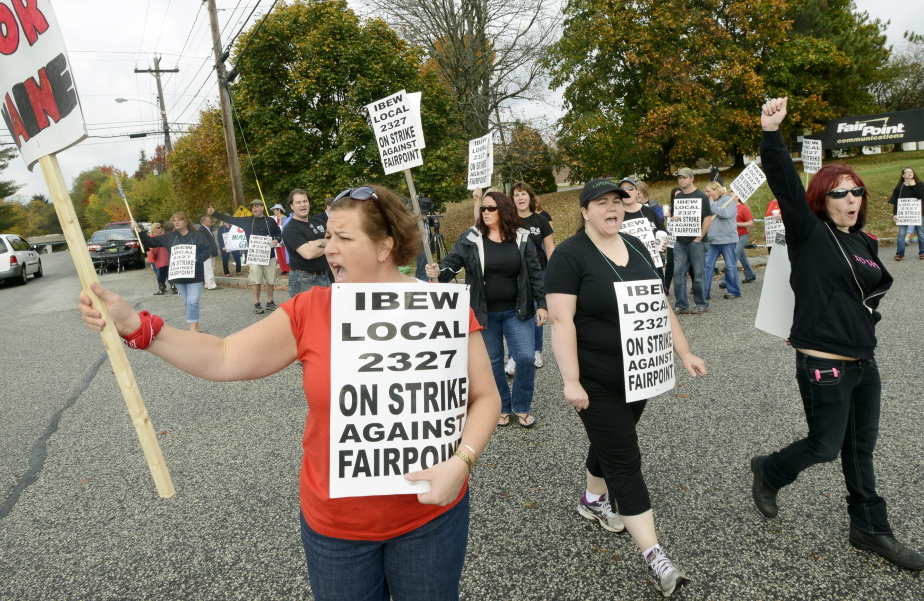 Renee Dugas, left, a 17-year employee, joins other FairPoint workers to walk a picket line Friday in front of the company’s Maine headquarters at 5 Davis Farm Road in Portland. Nearly 2,000 FairPoint employees went on strike at midnight Thursday.