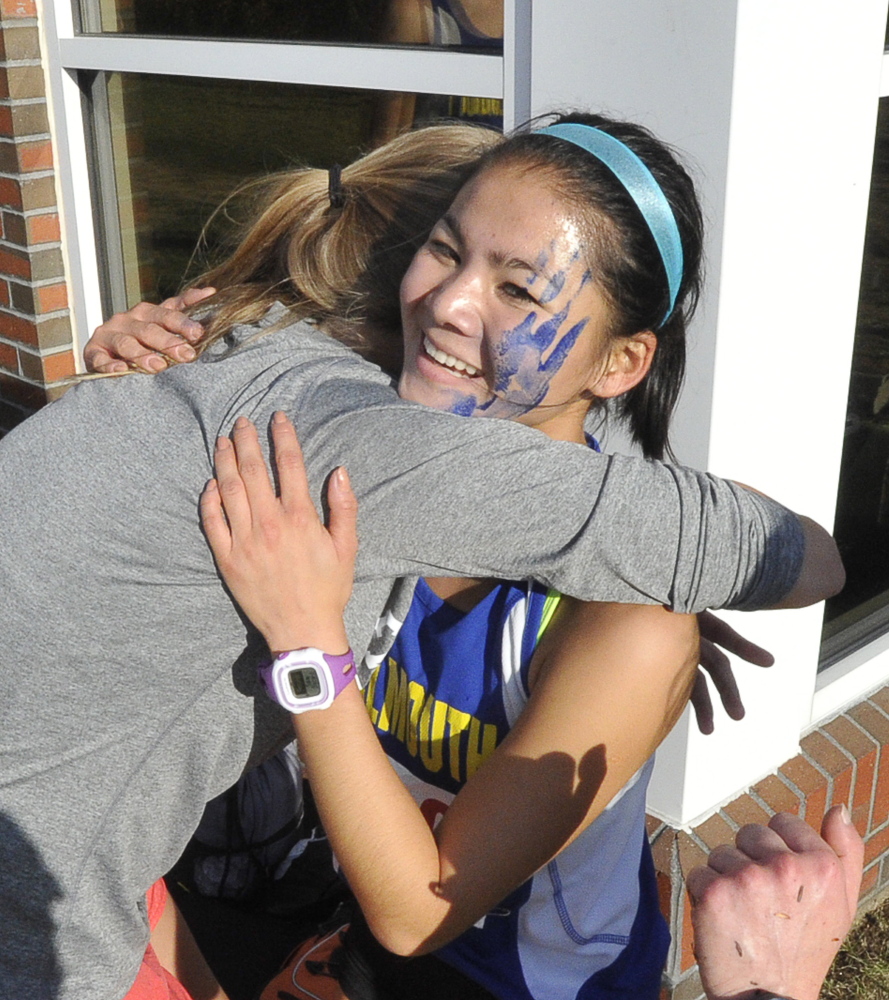 Mira Wyman of Falmouth receives a hug after capturing the Western Maine Conference girls’ championship in a time of 20 minutes, 17 seconds – finishing nine seconds ahead of Grace Cowles of Yarmouth.