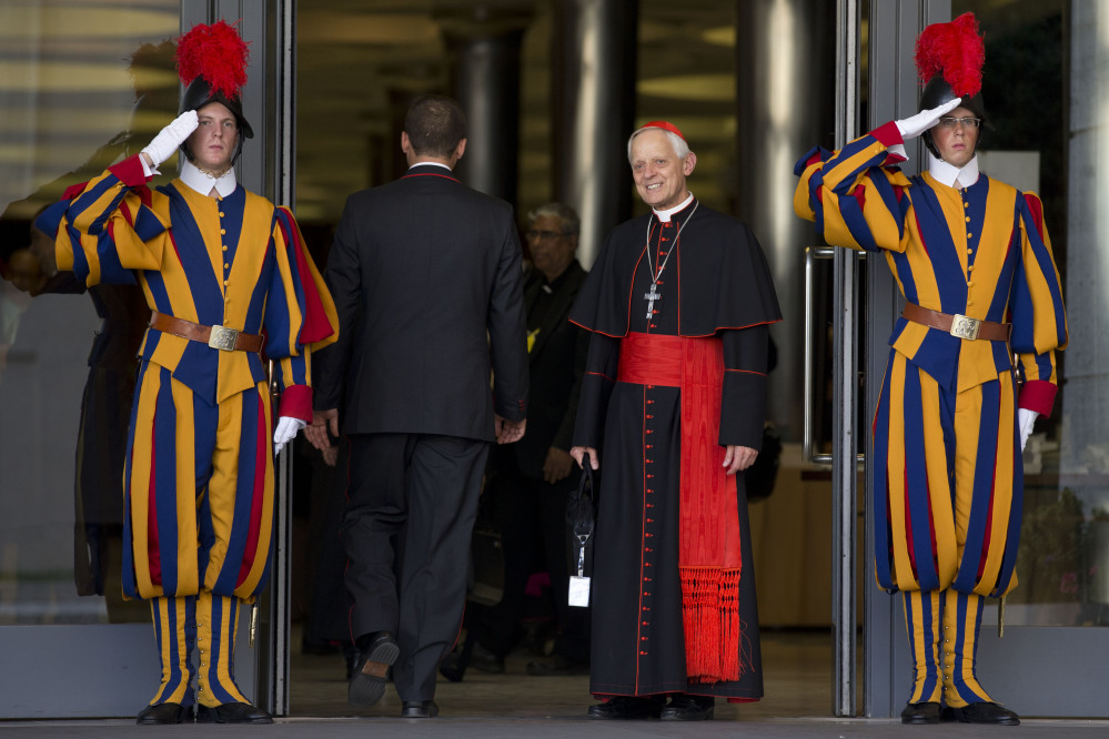 Cardinal Donald Wuerl, Archbishop of Washington, is saluted by two Swiss guards as he arrives to attend an afternoon session of a two-week synod on family issues at the Vatican on Saturday.