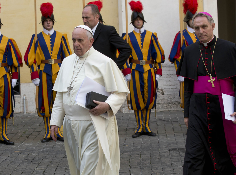 Pope Francis, left, arrives with Monsignor Georg Gaenswein at the Vatican on Friday. Bishops scrapped even a watered-down version of a document that had contained an overture to gays.