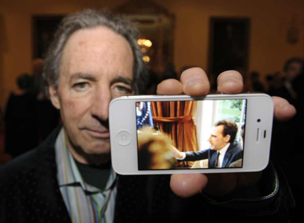 In this Jan. 9, 2013 file photo, actor Harry Shearer shows a photo of himself portraying President Richard Nixon for British network Sky Arts during a reception at the Richard Nixon Centennial Birthday Celebration in Washington.