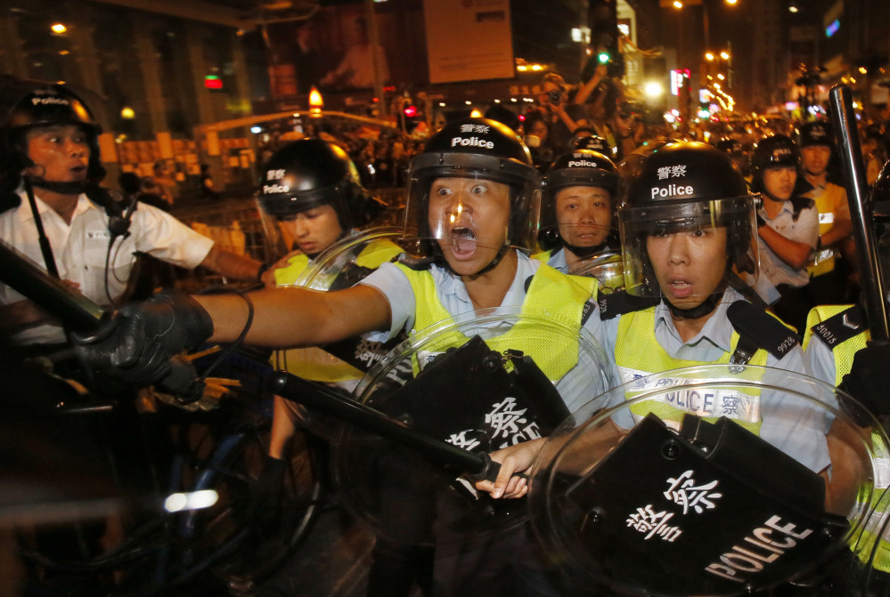 Riot police officers advance on a pro-democracy protest encampment in the Mong Kok district of Hong Kong on Saturday. The neighborhood is a flashpoint for protests.