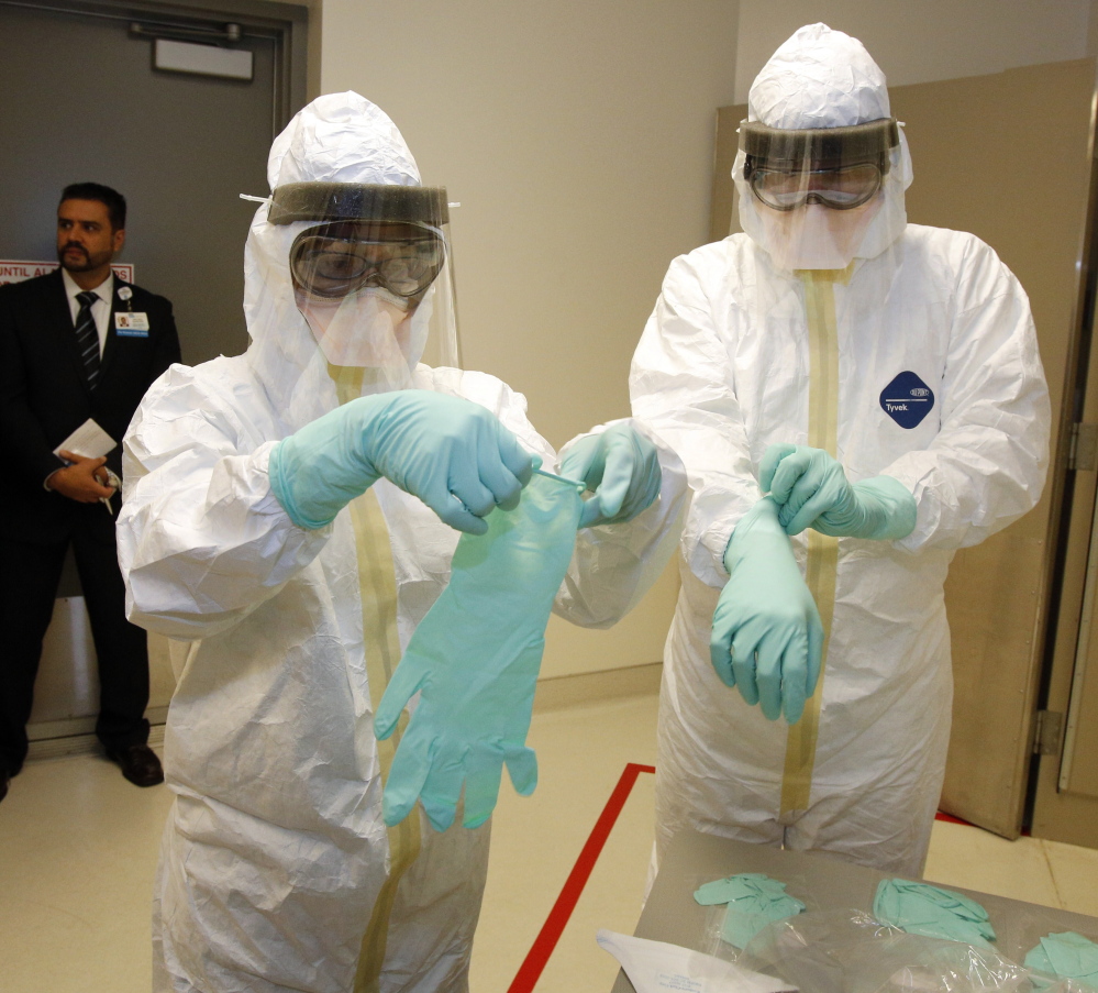 Medical staff participate try on protective clothing at the Ronald Reagan UCLA Medical Center in Los Angeles. Revised CDC guidelines will advise fully covering all skin.