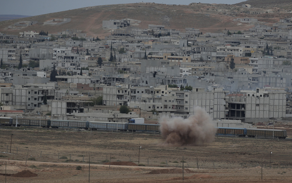Smoke rises from a mortar fired from inside Kobani, Syria, as it lands within Turkey, on the outskirts of Suruc, on Sunday. Kobani and its surrounding areas have been under assault by the Islamic State group since mid-September.