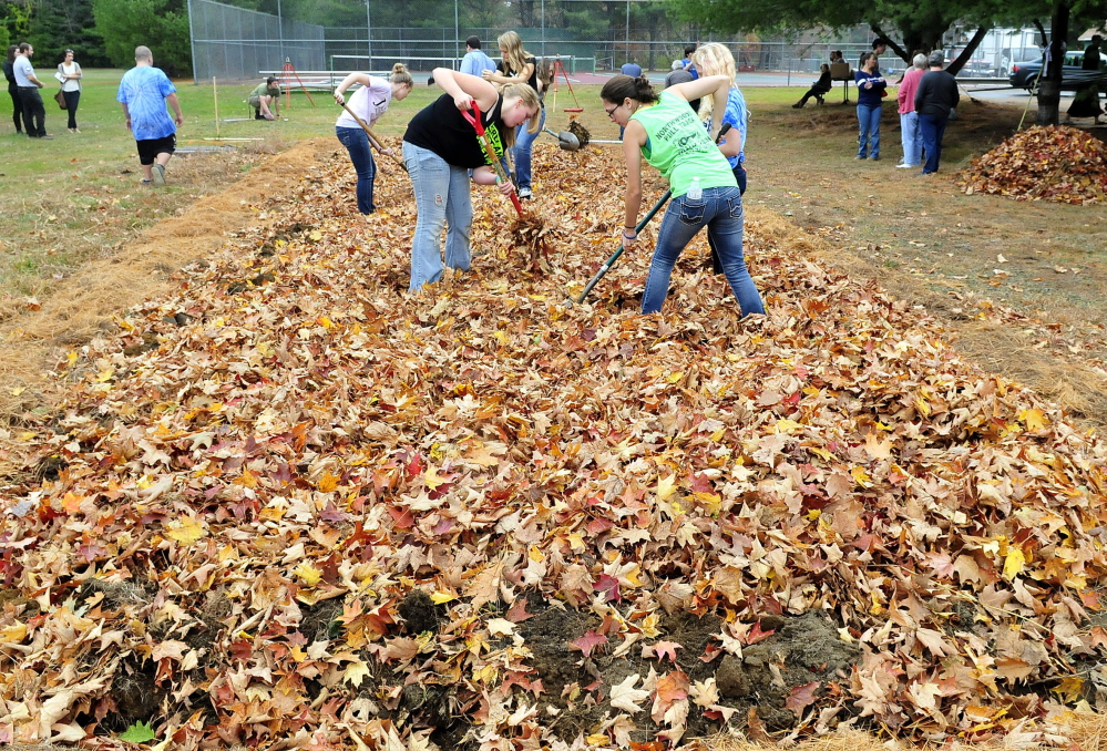 Carrabec High School students work leaves into a school garden plot for mulch. They gathered the leaves earlier Wednesday as part of a community service project.