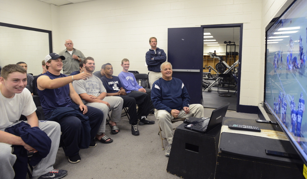 Coach Jim Hartman, right, and his Portland High School football team watch video Saturday morning of their most recent game against Lewiston. Thanks to an online video exchange service, teams can study not only their own game films but also those of opponents at the click of a button. John Patriquin/Staff Photographer