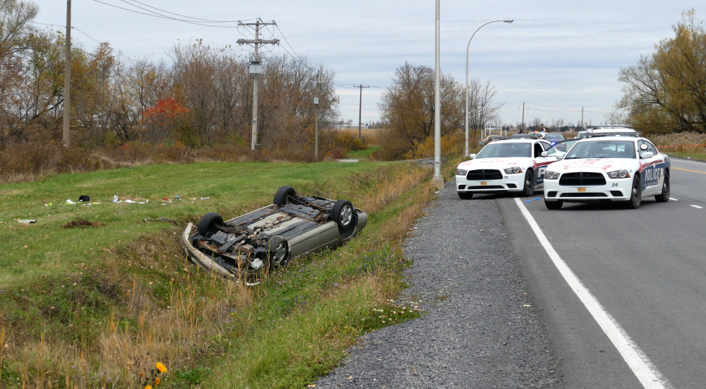 A car is seen Monday overturned in a ditch in a cordoned-off area in St-Jean-sur-Richelieu, Quebec. One of two soldiers hit by a car on Monday in Saint-Jean-sur-Richelieu, Que., died of his injuries early Tuesday, according to Quebec provincial police.