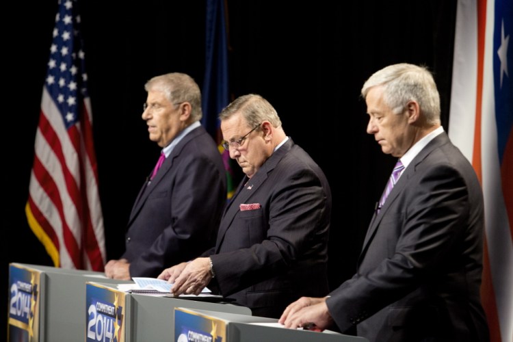 The three candidates for governor, from left independent Eliot Cutler, Republican Gov. Paul LePage and Democratic U.S. Rep. Mike Michaud, look over their notes as they prepare for Tuesday night’s debate at WMTW-TV’s studio in Auburn