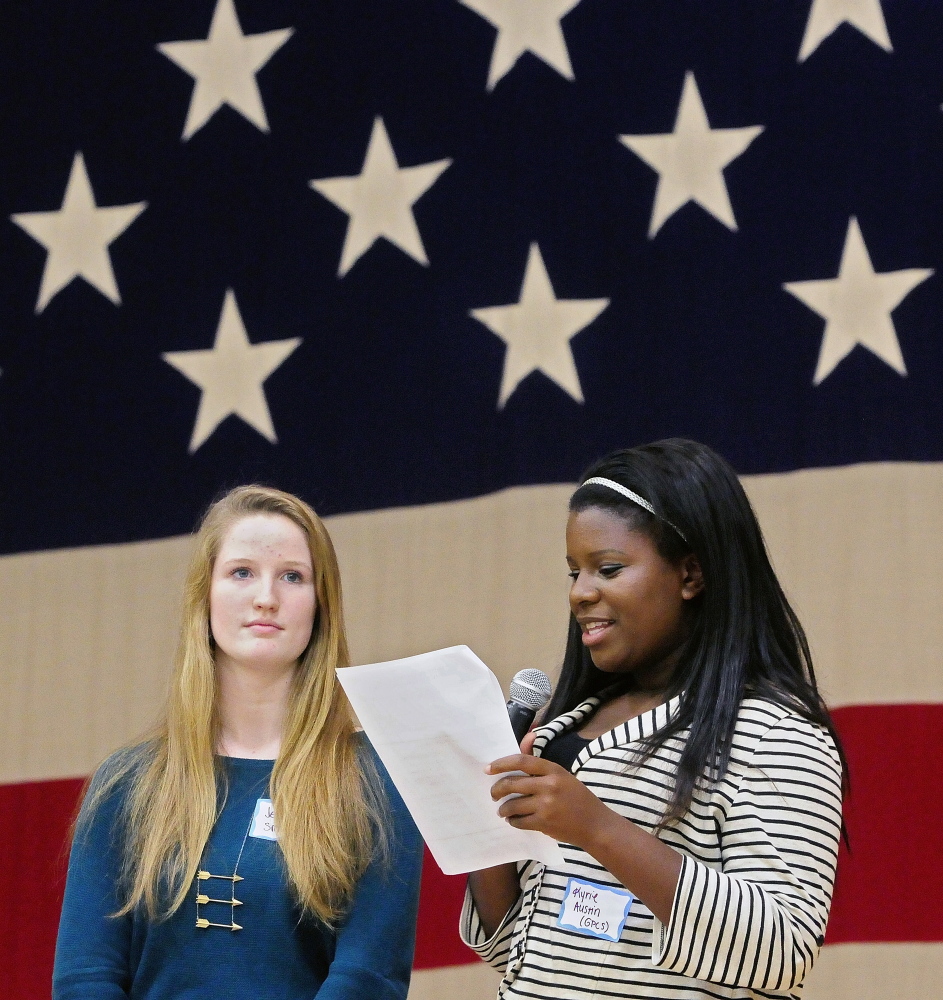 Greater Portland Christian School student Jess Smith, left, and Kyrie Austin read out results during the mock election rally-and-tally event Wednesday at the Augusta Armory.
