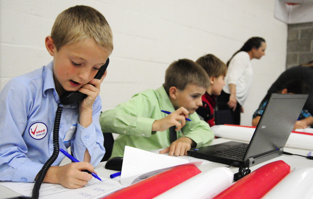 Fort Fairfield Elementary School students Alex Oakes, left, 11, and Chase Coiley, 10, take a turn working at the results station Wednesday at the Augusta Armory.