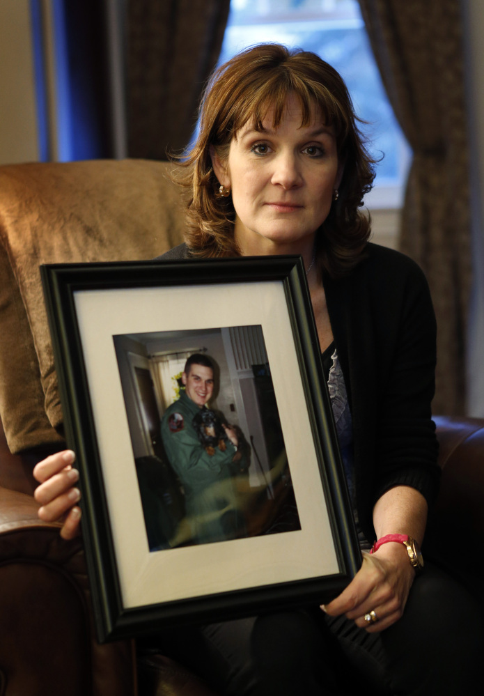 Hallie Twomey holds a photo of her son, C.J., at her home in of Auburn.