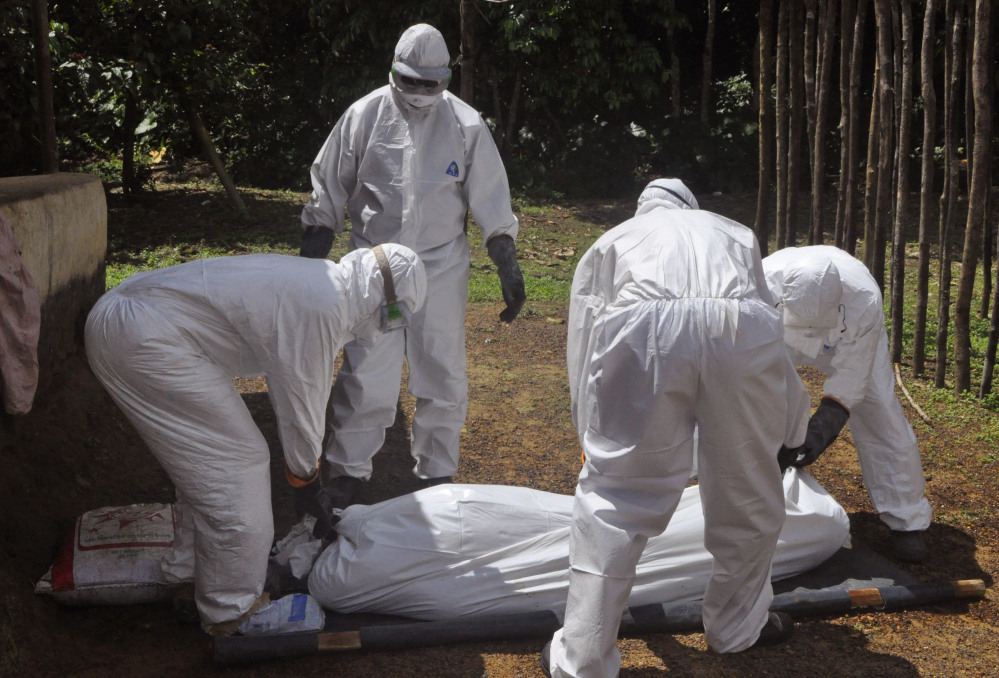 Health workers carry a victim suspected of contracting the Ebola virus in Monrovia, Liberia, on Monday. Nearly 5,000 people have died from the virus in Africa so far.