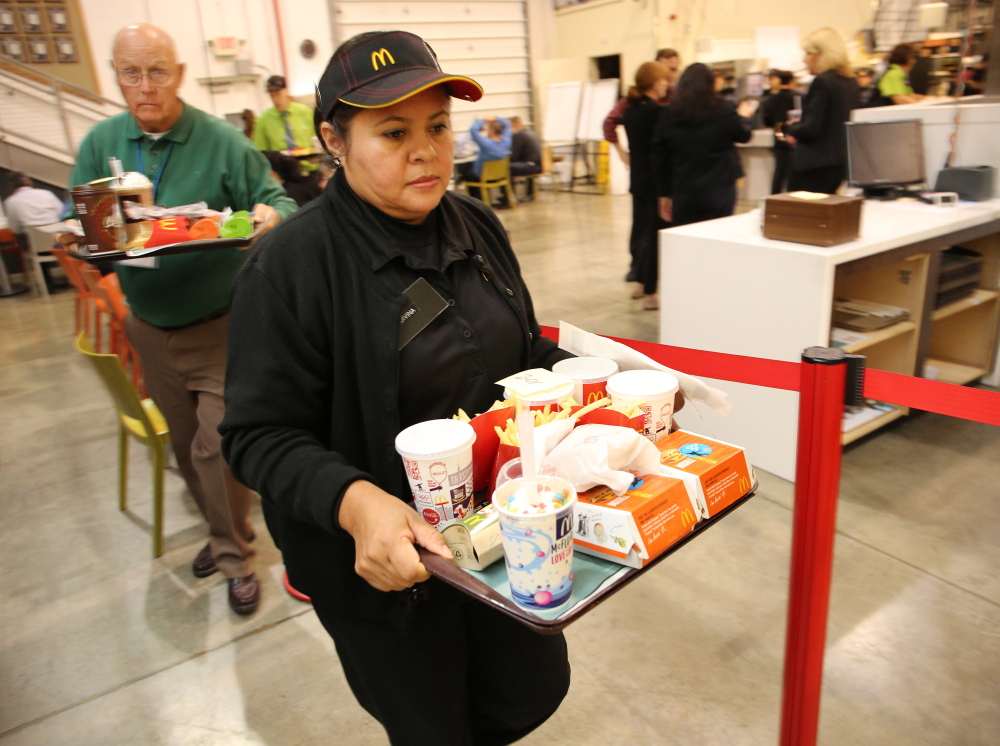 McDonald employees, trainees and staff carry back trays of food at a simulated Australian restaurant at the McDonald's Innovation Center in Romeoville, Ill. Antonio Perez/Chicago Tribune/MCT