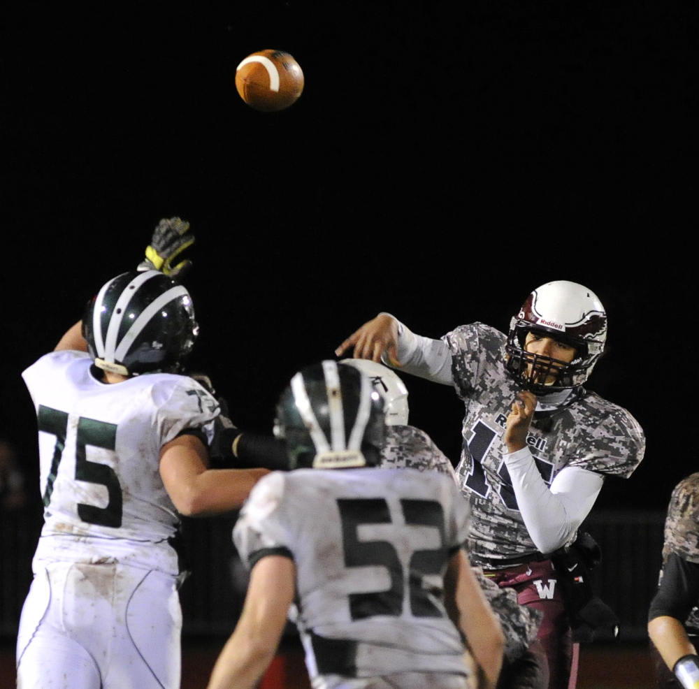 Windham quarterback Desmond Leslie throws a pass over Bonny Eagle’s Wiley Hollen, left, during their regular-season final Friday night in Windham. Windham won, 26-6.