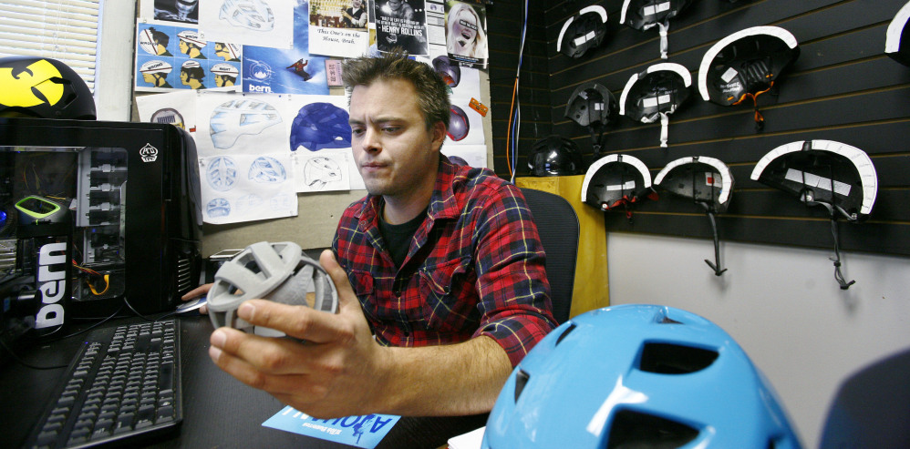 Ryan Melofchik of Bern Unlimited uses a computer and 3-D printer to create a sports helmet. The company is “super proud” to be an independent business in Massachusetts.