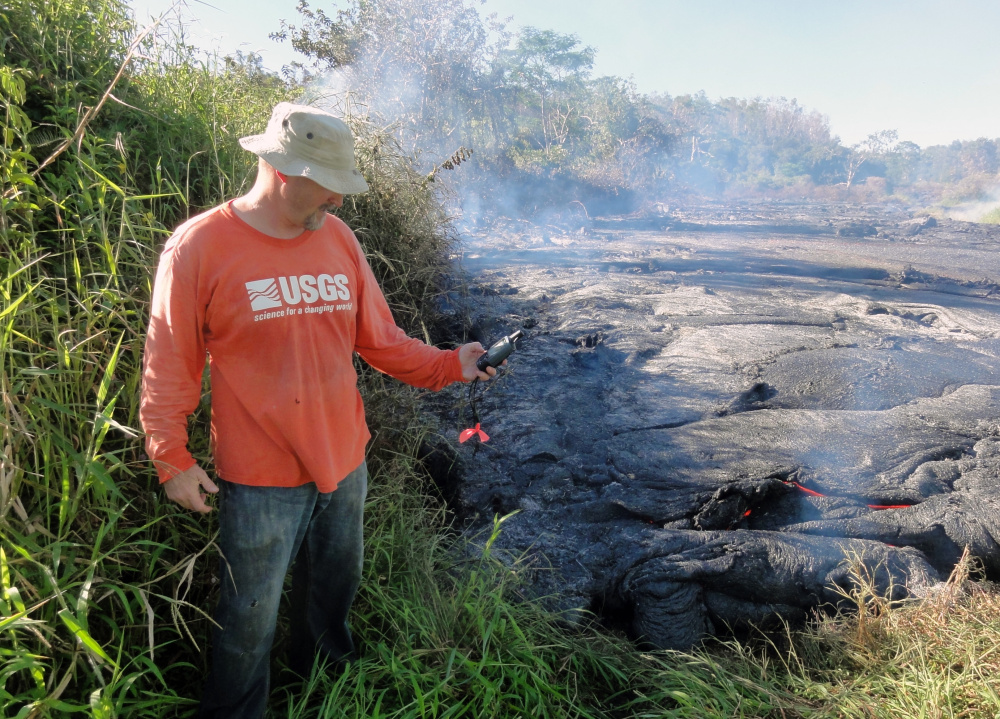 A geologist marks the coordinates of the Kilauea lava flow front with a GPS unit Wednesday. Lava from Kilauea volcano threatens the rural town of Pahoa, Hawaii.