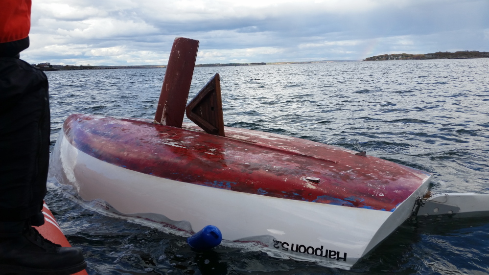 U.S. Coast Guard rescues three people from a capsized sailboat in the Portland Harbor Sunday afternoon.