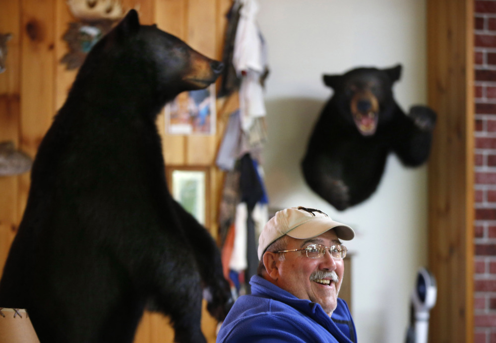 Jim Vohland talks with fellow out-of-state bear hunters at a hunting lodge in Wilton. Many hunters say a ban on bear baiting would devastate Maine outfitters and guides who rely on the fall bear hunt to bring in tourism dollars.