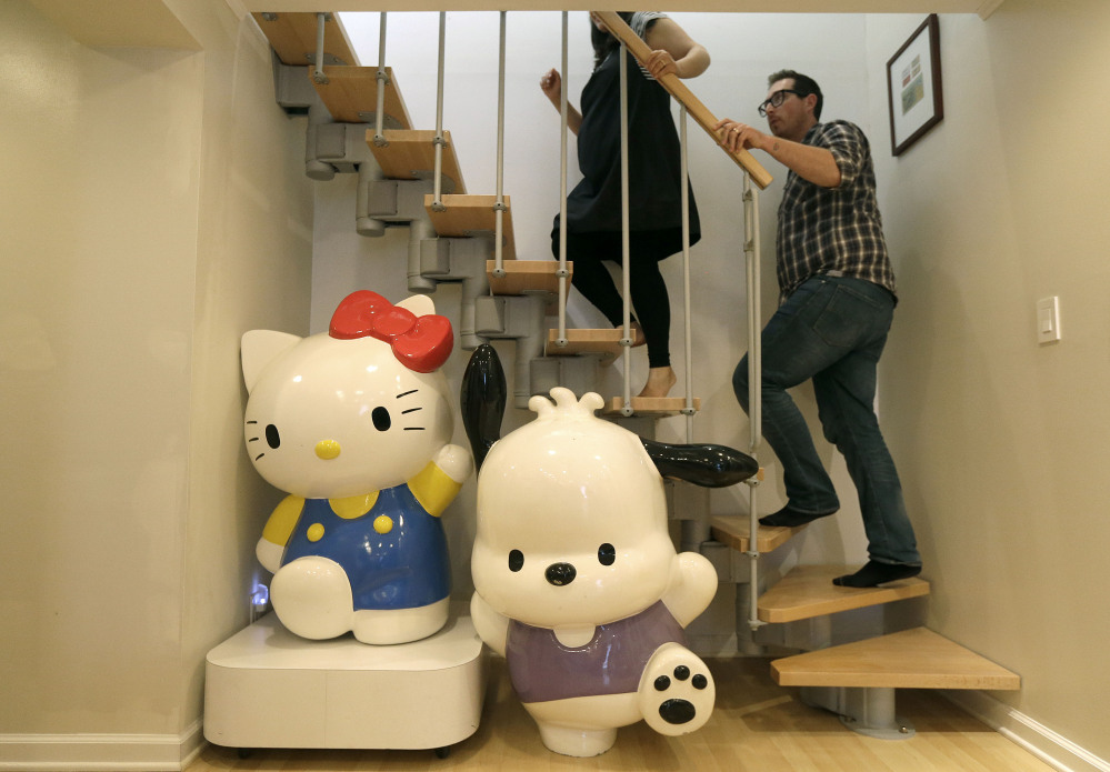 Salumeh Eslamieh and Marty Garrett walk up the stairs past statues of Sanrio characters Hello Kitty and Pochacco at their home in San Francisco this month. The couple turned their garage into a showroom for their vast Hello Kitty collection.