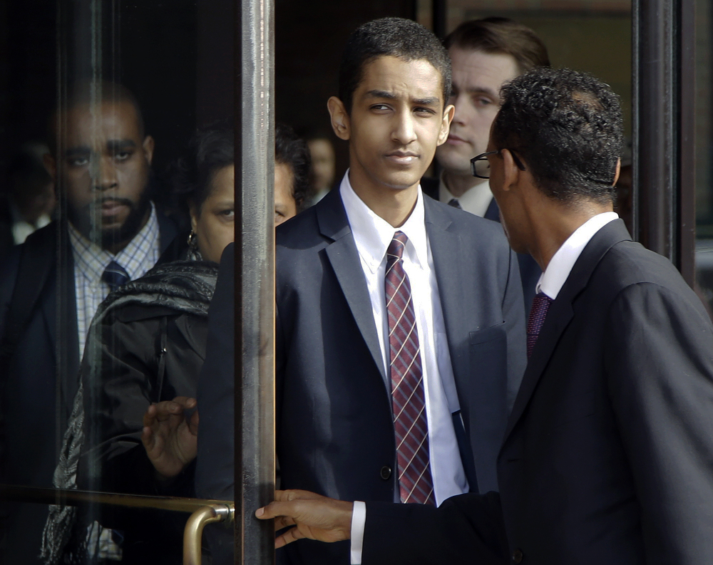 Robel Phillipos, center, departs federal court with defense attorney Derege Demissie, right, after he was convicted in Boston Tuesday on two counts of lying about being in the dorm room of Boston Marathon bombing suspect Dzhokhar Tsarnaev three days after the bombing in 2013, while two other friends removed a backpack containing fireworks and other potential evidence.
