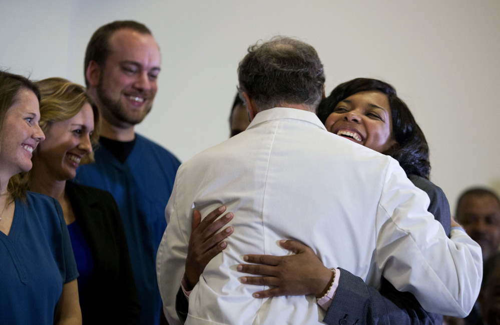 Amber Vinson, 29, the Dallas nurse who was being treated for Ebola, right, embraces Emory University Hospital epidemiologist Dr. Bruce Ribner, as she leaves a news conference after being discharged from the hospital Tuesday in Atlanta.