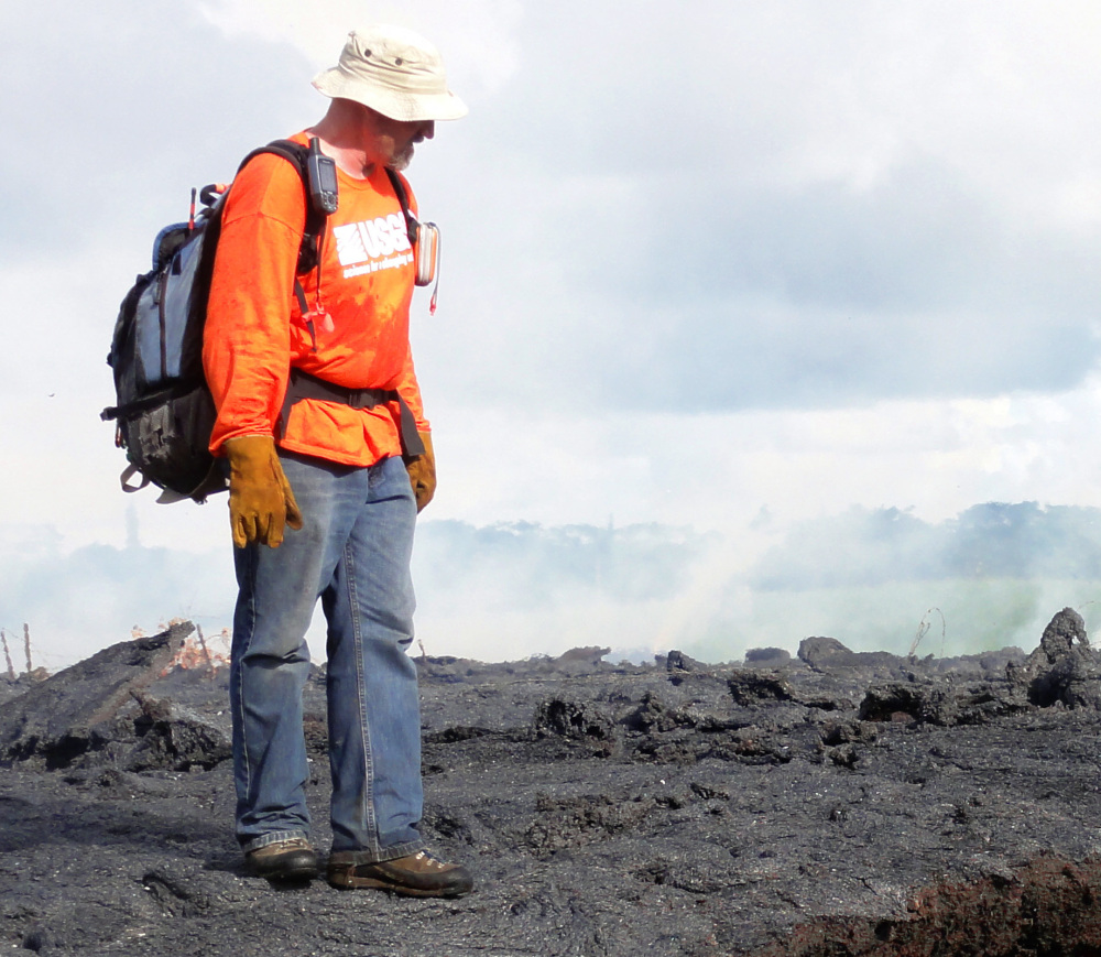 A Hawaii Volcano Observatory geologist stands on a cooled section of lava flow near the town of Pahoa.