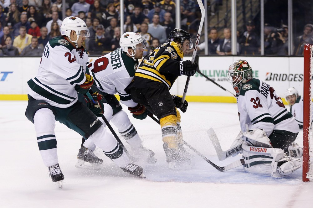 Boston Bruins’ center Seth Griffin scores on Minnesota Wild goalie Niklas Backstrom in the second period of Tuesday night’s game in Boston. The Bruins built a 3-1 lead after two periods but lost it in the third.