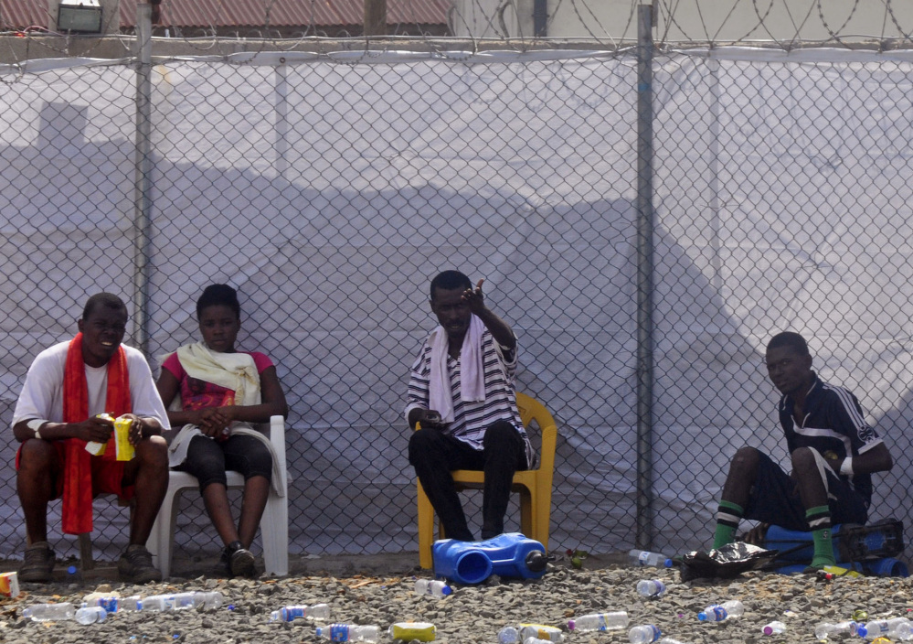Ebola patients sit inside the Island Clinic Treatment center, where they are kept under quarantine, in Monrovia, Liberia, on Wednesday.