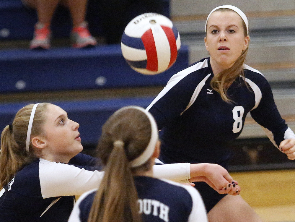 Alison Clark of Yarmouth prepares to hit the ball as Emily Parker, at right, keeps her eyes locked on the ball, and teammate Noelle Yunker, looks on during Yarmouth’s 3-0 Class B volleyball semifinal victory at home.