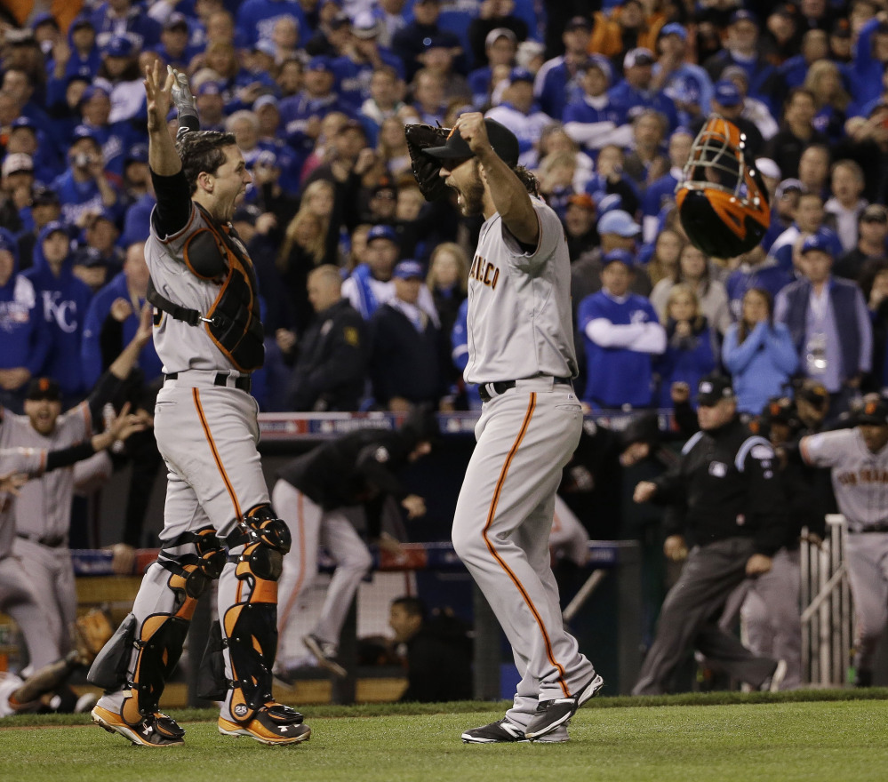 The San Francisco Giants’ Madison Bumgarner and catcher Buster Posey celebrate after winning Game 7 of the World Series against the Kansas City Royals on Wednesday night.