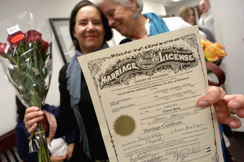 Laura Anne Chapman, left, and Jamie Whelan hold up their signed marriage certificate Oct. 17 in Flagstaff, Ariz., after becoming the second couple to be legally married in Coconino County. 
AP