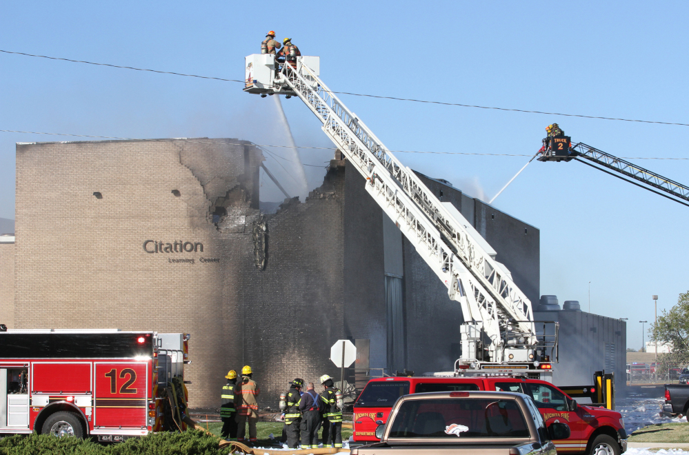 Firefighters try to put out a fire at Mid-Continent Airport in Wichita, Kan., Thursday, shortly after a small plane crashed into the building, killing several people.