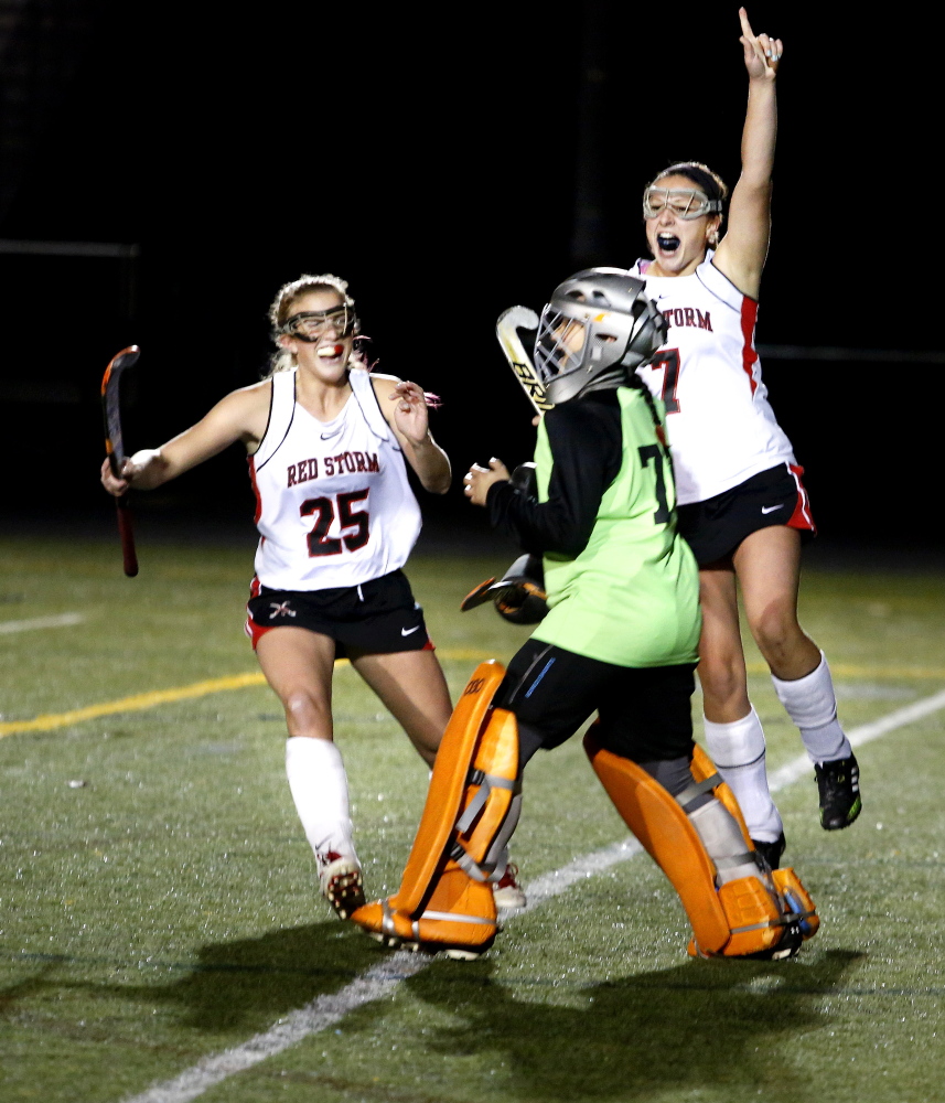 Scarborough teammates Kaitlin Prince, left, and Rose Kirsch, right, celebrate with goaltender Alyssa Souza after defeating Marshwood in the Class A Field Hockey Regional Championship Thursday. 