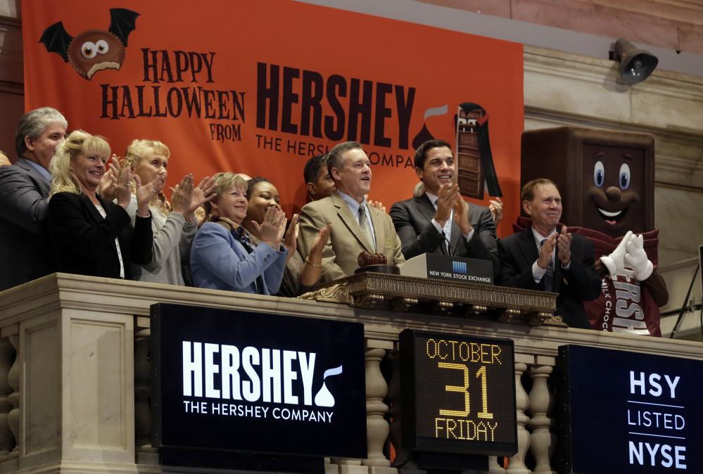 J.P. Bilbrey, president and chief executive officer of The Hershey Company, center, is applauded, including by a Hershey bar at right, as he rings the New York Stock Exchange opening bell Friday.
