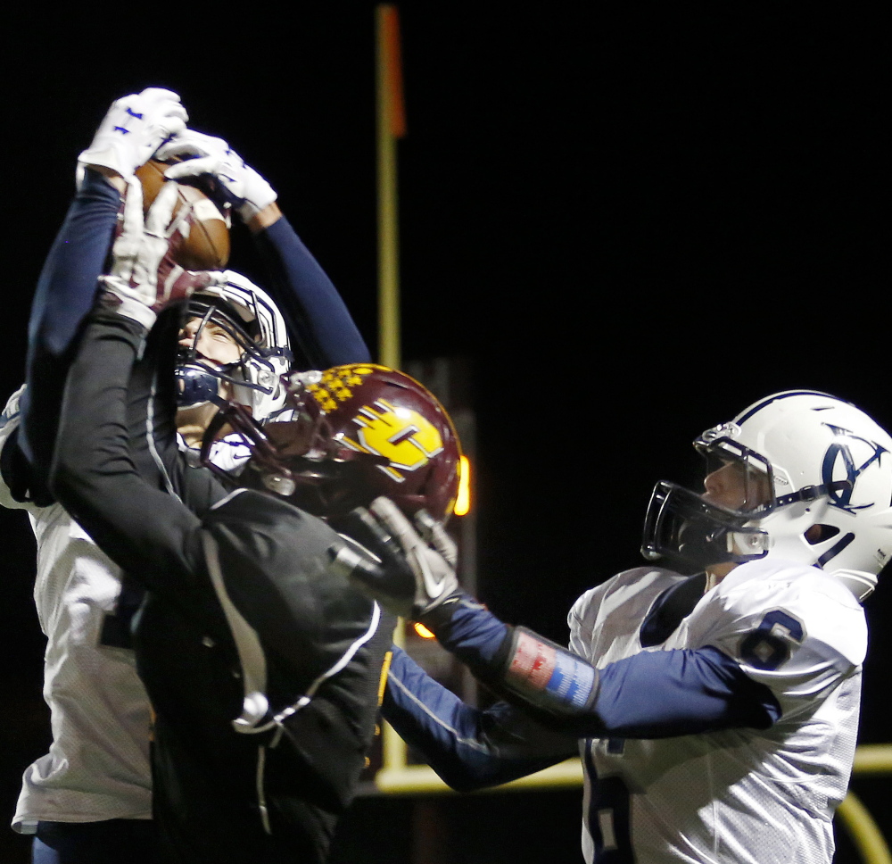 Cody Cook, left, of Yarmouth, intercepts a pass intended for Peyton Weatherbie of Cape Elizabeth while Jack Snyder also defends Friday night during a Western Class C football quarterfinal in Cape Elizabeth. Yarmouth won, 14-12.