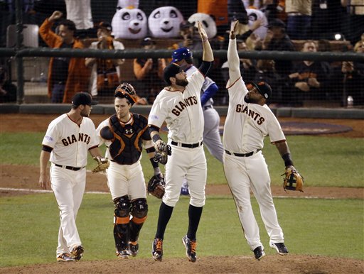San Francisco Giants' Pablo Sandoval, right, leaps for a high five with Brandon Belt as catcher Buster Posey and pitcher Hunter Strickland, far left, walk off the field after Game 4 of the World Series against the Kansas City Royals on Saturday in San Francisco. The Giants won the game 11-4 to tie the series 2-2. The Associated Press
