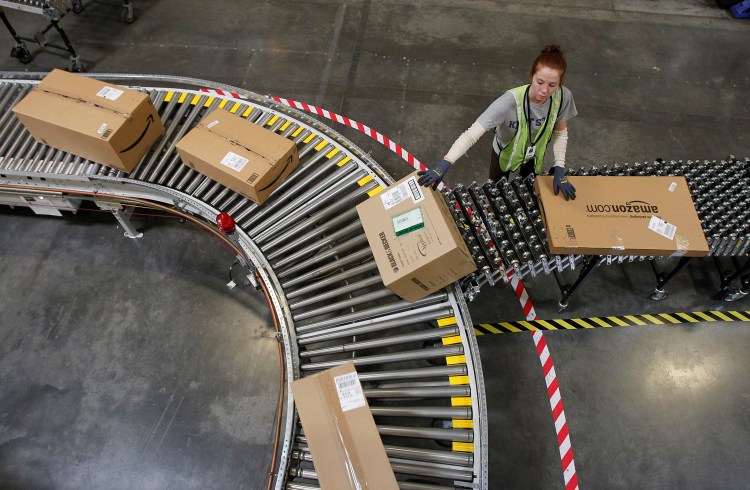 An employee, Katherine Braun sorts packages at an Amazon.com fulfillment center in Goodyear, Ariz. Amazon is hiring 80,000 seasonal workers for its distribution centers as it looks to improve its shipping efficiency during the crucial 2014 holiday season. 