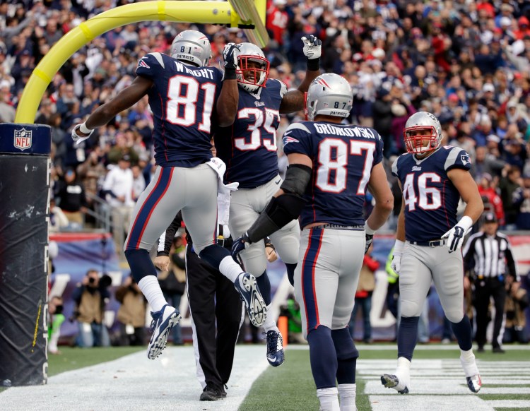 Timothy Wright, 81, celebrates his touchdown catch with running back Jonas Gray in Sunday's game at Foxborough, Mass. The Associated Press