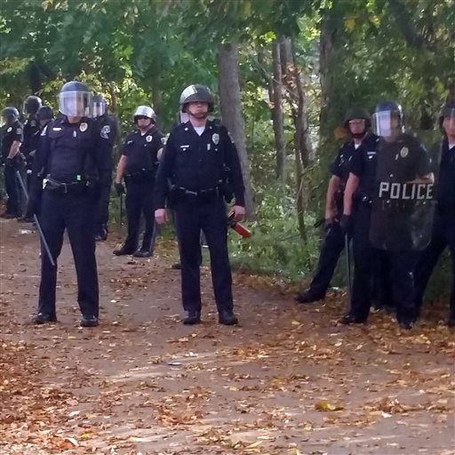 In this photo provided by Seth Meyer,  police officers prepare to respond to large crowds of rowdy students near Keene State College Saturday. The Associated Press