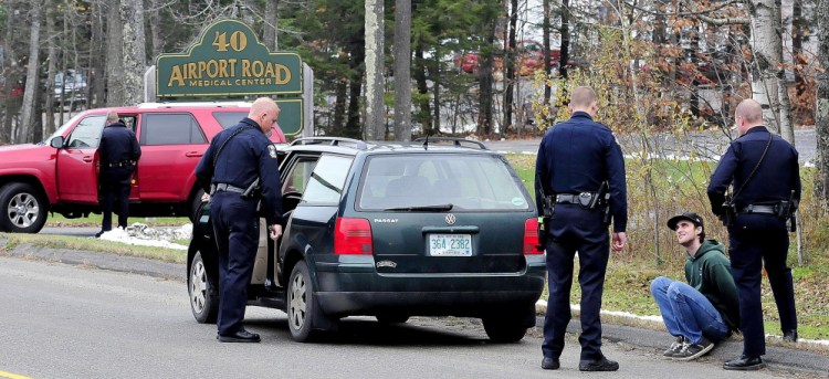 Joseph Ciampa is interviewed by Waterville police as an officer searches a car on Airport Road on Wednesday.  David Leaming / Waterville Sentinel Staff Photographer