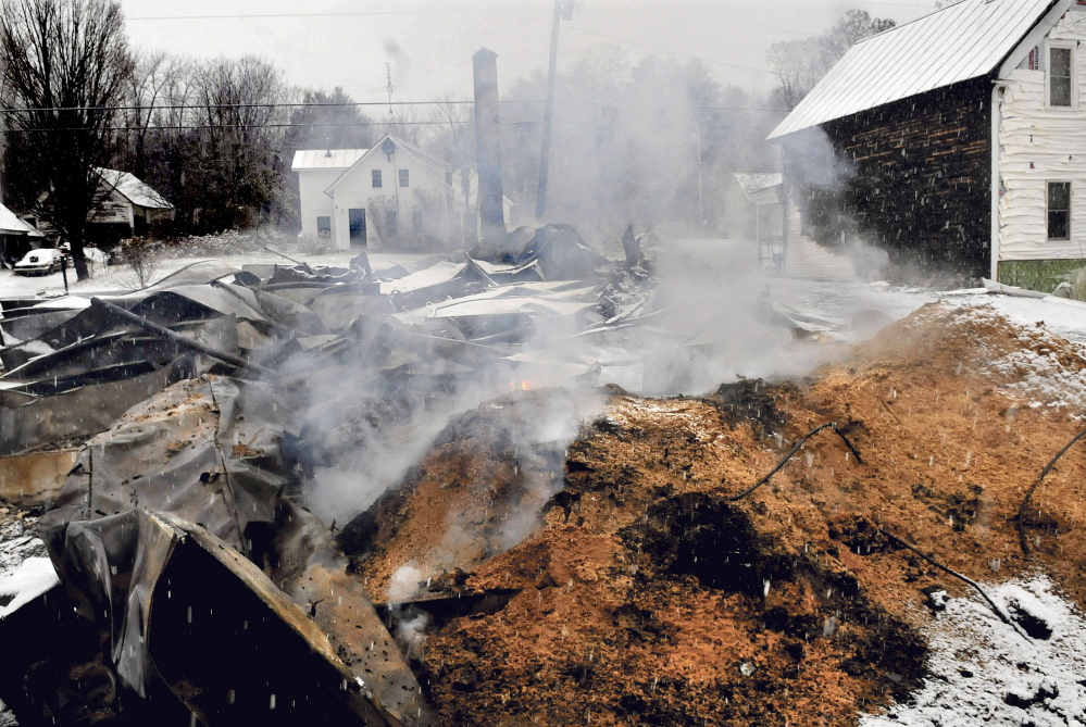 moke and flames rise from a large pile of pellets behind the home of Rick and Tina Belanger on Monday hours after fire destroyed their Main Street home in Caratunk. In the background is the home of Dan and Marie Beane who own the post office property and called in the fire. David Leaming/Morning Sentinel Staff Photographer