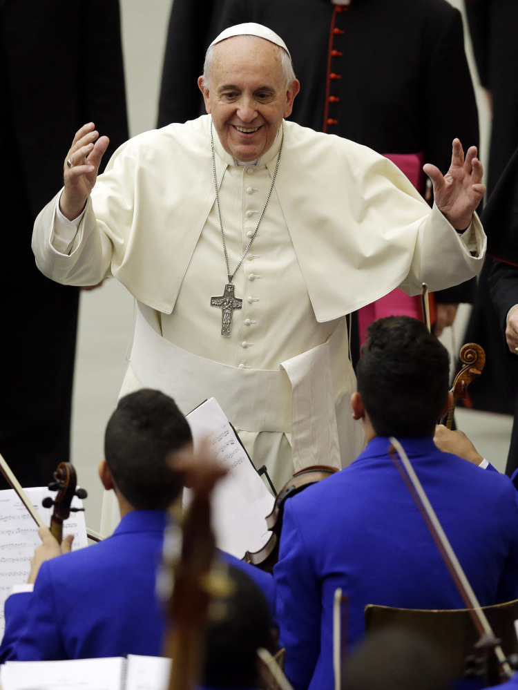 Pope Francis greets a youth orchestra at the Vatican on Friday. The pope has recently spoken out on policy issues ranging from creation and evolution to exorcism.