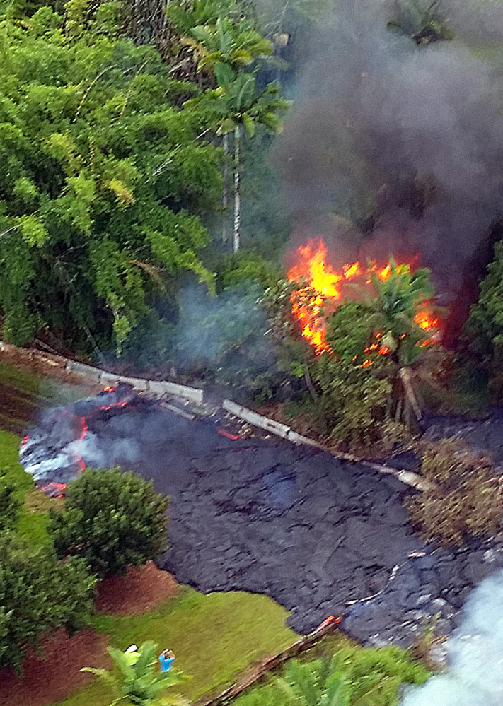 A structure burns as lava flows around it near the town of Pahoa, Hawaii, on Tuesday.