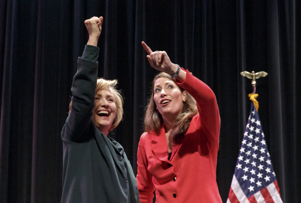 Hillary Rodham Clinton appears with Alison Lundergan Grimes on Saturday. Clinton cited equal pay for women and emphasized women’s reproductive rights at a campaign event for Grimes, who is trying to unseat Kentucky Sen. Mitch McConnell.