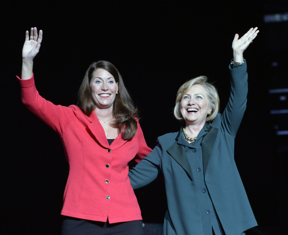 Kentucky democratic senatorial candidate Alison Lundergan Grimes, left, and former Secretary of State Hillary Clinton wave to a group of supporters during a rally in Highland Heights, Ky., Saturday, Nov. 1, 2014. (AP Photo/Timothy D. Easley)