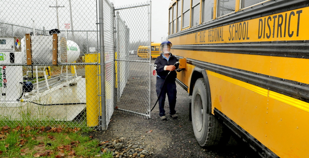 RSU 9 bus driver Nancy Richardson wears protective gear while filling one of four new buses with propane Wednesday.