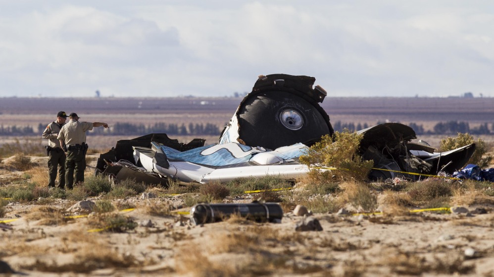Law enforcement officers take a closer look at the wreckage near the site where a Virgin Galactic space tourism rocket, SpaceShipTwo, exploded and crashed in Mojave, Calif. Saturday.