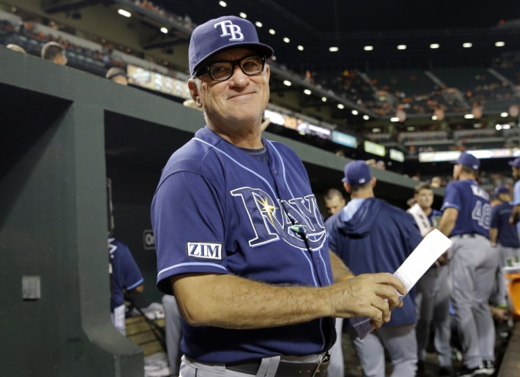 In this Aug. 27, 2014, file photo, Tampa Bay Rays manager Joe Maddon smiles at a fan in the stands in the fifth inning of a baseball game against the Baltimore Orioles in Baltimore.