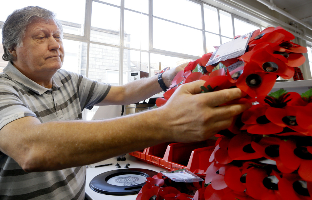 William Sellick, a former soldier who served in Northern Ireland, makes a wreath at the Poppy Factory in Richmond near London on Thursday. He finds the work helps him to face a life shadowed by depression and alcoholism.